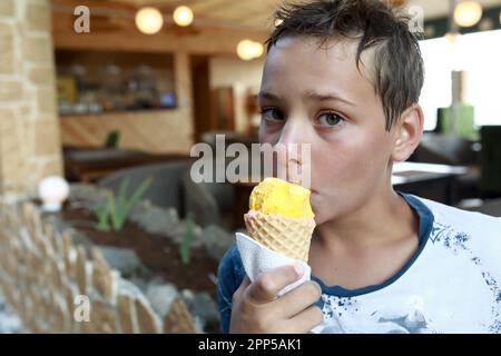 Porträt eines Jungen, der im Freien Eiscreme isst Stockfoto