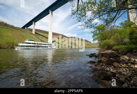 Erden, Deutschland. 22. April 2023. Das Ausflugsboot 'Moselkönigin' fährt bei schönem Wetter unter der Hochmoselbrücke auf der Mosel hindurch. Das Wetter soll sich in der Region am Wochenende ändern. Kredit: Harald Tittel/dpa/Alamy Live News Stockfoto