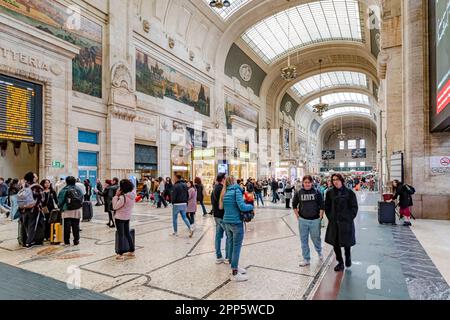 Menschen, die durch das herrliche Innere der Eingangshalle im Erdgeschoss des Mailänder Hauptbahnhofs in Mailand, Italien, spazieren Stockfoto