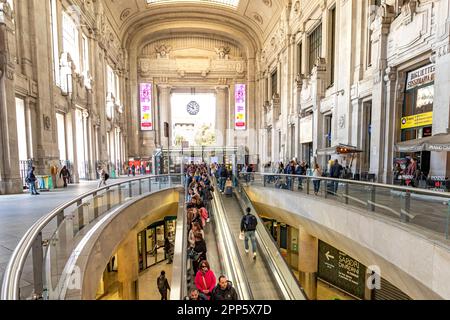 Personen, die eine Rolltreppe im Inneren der Eingangshalle im Erdgeschoss des Mailänder Hauptbahnhofs in Mailand, Italien, benutzen Stockfoto