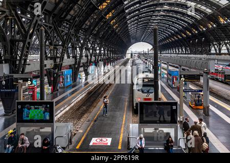 Ein Mann und ein Kind stehen auf dem Bahnsteig unter dem riesigen Bogendach am Mailänder Hauptbahnhof, Mailand, Italien Stockfoto