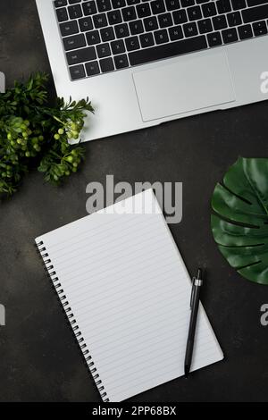 Arbeitsplatz mit leerem Notebook und Laptop auf schwarzem Hintergrund. Draufsicht mit Kopierbereich. Stockfoto