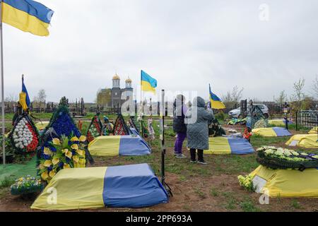 17. April 2023, Odessa, Ukraine: Angehörige toter Soldaten und Offiziere der ukrainischen Streitkräfte sahen sich in der Nähe von Gräbern mit Blumen und ukrainischen Flaggen auf dem westlichen Friedhof am Vorabend der Provodie (Radonitsa). Provody (Radonitsa) ist die zweite Woche nach Ostern, was nach ukrainischer Tradition ein Denkmal für verstorbene Verwandte ist. Die Tradition von Radovnytsia stammt aus heidnischen Zeiten und ist eng mit dem alten Kult der Vorfahren verbunden. Unter den antiken Slawen war Radonitsa (oder „Springfreudigkeit“) wahrscheinlich der Name für einen ganzen Zyklus von Frühlingsferien, die Zeit des Gedenkens Stockfoto