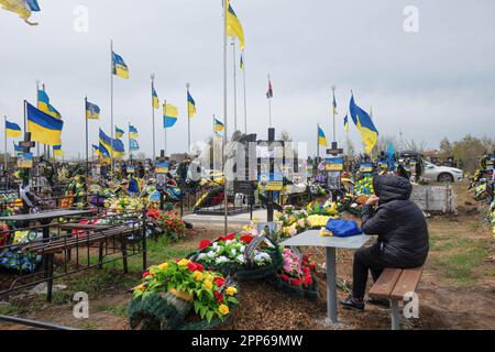 17. April 2023, Odessa, Ukraine: Blumen und ukrainische Flaggen auf den Gräbern von Soldaten und Offizieren der ukrainischen Streitkräfte auf dem westlichen Friedhof am Vorabend der Provody (Radonitsa). Provody (Radonitsa) ist die zweite Woche nach Ostern, was nach ukrainischer Tradition ein Denkmal für verstorbene Verwandte ist. Die Tradition von Radovnytsia stammt aus heidnischen Zeiten und ist eng mit dem alten Kult der Vorfahren verbunden. Unter den alten Slawen war Radonitsa (oder „Springfreudigkeit“) wahrscheinlich der Name für einen ganzen Zyklus von Frühjahrsferien, die Zeit des Gedenkens an die Toten. Acco Stockfoto