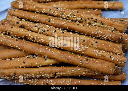 Ein Haufen Brotstangen, auch bekannt als Grissini, grissino oder Dipping Stäbchen, bleistiftgroße Stangen knuspriges, trocken gebackenes Brot, salzig mit Kreuzkümmel und überzogenem wi Stockfoto