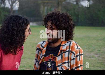 Ein paar Freunde saßen im Park und unterhielten sich und amüsierten sich Stockfoto