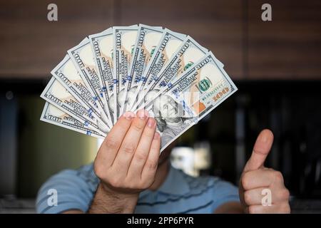 Geschäftsmann zählt Banknoten. Männerhände, die 1000 Dollar in Betracht ziehen. In den Händen einer Menge Geld, Stückelungen von 100 Dollar. Der Mann hat ein Bündel Einsen Stockfoto