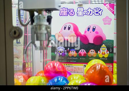 Edgewater,. NJ - 13. April 2023 : niedliches pinkfarbenes Nintendo-Videospiel Kirby-Figur Merchandise Crane Spielzeichen in japanischer Sprache mit Logo Stockfoto