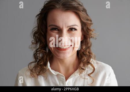 Gesicht einer glücklichen, reifen Frau mit lockigem Haar, die in die Kamera schaut Stockfoto