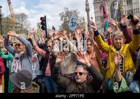 London, Großbritannien. Menschen heben die Hand und sagen, dass sie mehr tun werden. Viele Tausende von Rebellion-Anhängern marschieren von einer Kundgebung außerhalb der Westminster Abbey am Earth Day, um die Natur und alle vom Aussterben bedrohten Arten zu ehren und zu respektieren. Sie wurden von Schlagzeugern in Blöcken angeführt und hielten an mehreren Stellen an, um Vogelgesang auf all ihren Telefonen zu spielen. So viele nahmen Teil, dass sich das stille Sterben für verlorene und bedrohte Arten, das für den Parliament Square geplant war, von der Lambeth Bridge bis zum St. James's Park ausbreitete. Peter Marshall/Alamy Live New Stockfoto