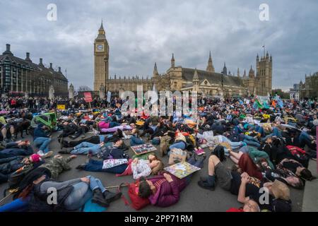 London, Großbritannien. Die-in - Parlamentsgebäude. Viele Tausende von Rebellion-Anhängern marschieren von einer Kundgebung außerhalb der Westminster Abbey am Earth Day, um die Natur und alle vom Aussterben bedrohten Arten zu ehren und zu respektieren. Sie wurden von Schlagzeugern in Blöcken angeführt und hielten an mehreren Stellen an, um Vogelgesang auf all ihren Telefonen zu spielen. So viele nahmen Teil, dass sich das stille Sterben für verlorene und bedrohte Arten, das für den Parliament Square geplant war, von der Lambeth Bridge bis zum St. James's Park ausbreitete. Peter Marshall/Alamy Live New Stockfoto