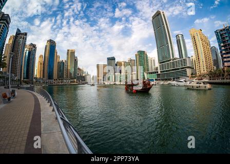 Dubai, Vereinigte Arabische Emirate - 2. April 2023: Fischaugenblick auf das Dhow-Boot, das den Hafen für eine Bootstour bei Sonnenuntergang am späten Nachmittag verlässt Stockfoto