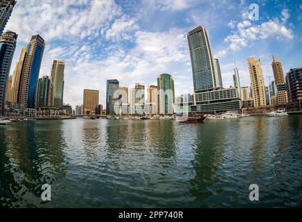 Dubai, Vereinigte Arabische Emirate - 2. April 2023: Fischaugenblick auf das Dhow-Boot, das den Hafen für eine Bootstour bei Sonnenuntergang am späten Nachmittag verlässt Stockfoto