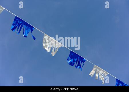 Eine Reihe abwechselnder weißer und blauer Flaggen in den Farben der israelischen Flagge. Stockfoto