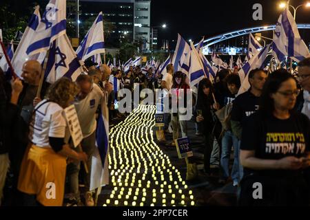 Tel Aviv, Israel. 22. April 2023. Während eines Protests gegen die rechtsgerichtete israelische Regierung zünden Demonstranten Kerzen an und wedeln mit Flaggen. Kredit: Ilia Yefimovich/dpa/Alamy Live News Stockfoto