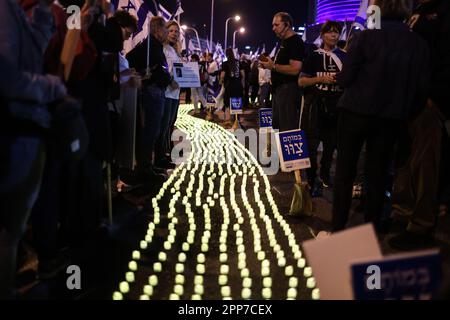 Tel Aviv, Israel. 22. April 2023. Während eines Protests gegen die rechtsgerichtete israelische Regierung zünden Demonstranten Kerzen an und wedeln mit Flaggen. Kredit: Ilia Yefimovich/dpa/Alamy Live News Stockfoto