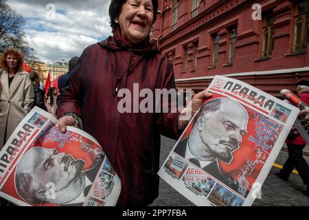 Moskau, Russland. 22. April 2023. Eine ältere Frau hält die Zeitung einer kommunistischen Partei "Pravda" (eng: Wahrheit) während einer Zeremonie, bei der Blumen und Kränze in Lenins Mausoleum auf dem Roten Platz gelegt werden, und feiert 153 Jahre nach Wladimir Lenins Geburt in Russland. Nikolay Vinokurov/Alamy Live News Stockfoto