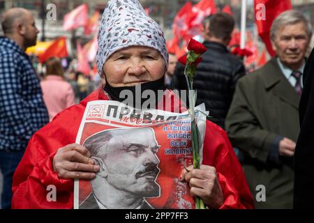 Moskau, Russland. 22. April 2023. Eine ältere Frau hält die Zeitung einer kommunistischen Partei "Pravda" (eng: Wahrheit) während einer Zeremonie, bei der Blumen und Kränze in Lenins Mausoleum auf dem Roten Platz gelegt werden, und feiert 153 Jahre nach Wladimir Lenins Geburt in Russland. Nikolay Vinokurov/Alamy Live News Stockfoto