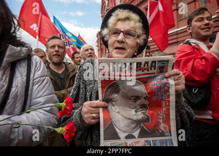 Moskau, Russland. 22. April 2023. Eine ältere Frau hält die Zeitung einer kommunistischen Partei "Pravda" (eng: Wahrheit) während einer Zeremonie, bei der Blumen und Kränze in Lenins Mausoleum auf dem Roten Platz gelegt werden, und feiert 153 Jahre nach Wladimir Lenins Geburt in Russland. Nikolay Vinokurov/Alamy Live News Stockfoto