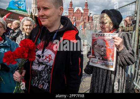 Moskau, Russland. 22. April 2023. Eine ältere Frau hält die Zeitung einer kommunistischen Partei "Pravda" (eng: Wahrheit) während einer Zeremonie, bei der Blumen und Kränze in Lenins Mausoleum auf dem Roten Platz gelegt werden, und feiert 153 Jahre nach Wladimir Lenins Geburt in Russland. Nikolay Vinokurov/Alamy Live News Stockfoto