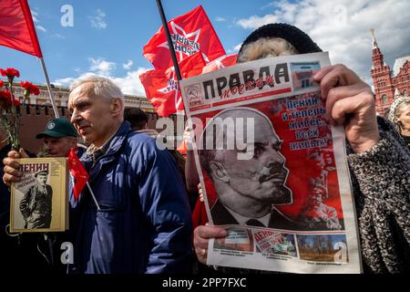 Moskau, Russland. 22. April 2023. Eine ältere Frau hält die Zeitung einer kommunistischen Partei "Pravda" (eng: Wahrheit) während einer Zeremonie, bei der Blumen und Kränze in Lenins Mausoleum auf dem Roten Platz gelegt werden, und feiert 153 Jahre nach Wladimir Lenins Geburt in Russland. Nikolay Vinokurov/Alamy Live News Stockfoto