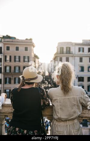 Zwei Frauen blicken über Rom, Italien, von der Spanischen Treppe bei Sonnenuntergang an einem klaren, wunderschönen Abend Stockfoto