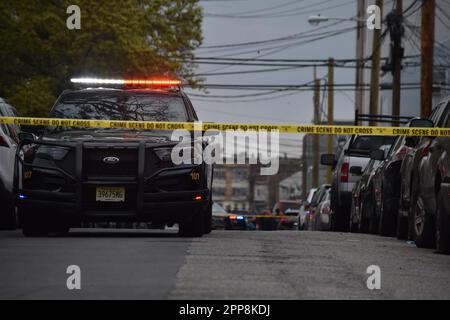 Paterson, Usa. 22. April 2023. Das Polizeifahrzeug von Paterson blockiert den Tatort für den Fahrzeugverkehr. Samstagnachmittag wurde gegen eine Schießerei in der Beech Street ermittelt. Auf dem Boden wurden Patronenhülsen vorgefunden, und es wurden keine Verletzungen gemeldet. Die Polizei von Paterson sperrte die Straße für eine Weile, während sie den Tatort in der Beech Street untersuchten. Kredit: SOPA Images Limited/Alamy Live News Stockfoto