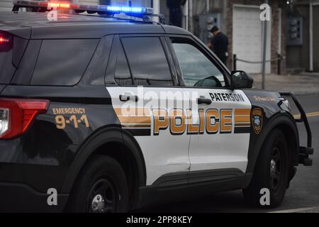 Paterson, Usa. 22. April 2023. Das Polizeifahrzeug von Paterson blockiert den Tatort für den Fahrzeugverkehr. Samstagnachmittag wurde gegen eine Schießerei in der Beech Street ermittelt. Auf dem Boden wurden Patronenhülsen vorgefunden, und es wurden keine Verletzungen gemeldet. Die Polizei von Paterson sperrte die Straße für eine Weile, während sie den Tatort in der Beech Street untersuchten. Kredit: SOPA Images Limited/Alamy Live News Stockfoto