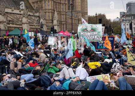 London, Großbritannien. 22. April 2023. Die Demonstranten sahen das Liegen auf dem Boden als eine eingefleischte Leistung, um die britische Regierung zu drängen, die Klimakrise während des marsches vor dem britischen Parlament als eine Notlage zu betrachten. Aussterbende Rebellionen, eine massenhafte Gruppe von Aktivisten aus verschiedenen Disziplinen, die sich in erster Linie um die Klimakrise sorgen, setzen ihre Massenkampagne am Tag der Erde fort. Dies ist die erste Kampagne, seit sich die Gruppe seit Ende letzten Jahres verpflichtet hat, von kontroversen disruptiven Methoden abzuweichen. Kredit: SOPA Images Limited/Alamy Live News Stockfoto