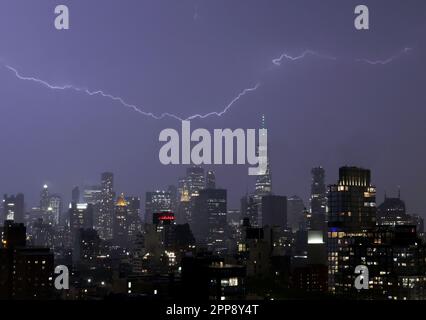 New York, Usa. 22. April 2023. Während eines Gewittersturms schießt ein Blitz über die Skyline von Manhattan, während der Turm des One World Trade Center grün leuchtet, um den Earth Day in New York City am Samstag, den 22. April 2023, zu feiern. Foto: John Angelillo/UPI Credit: UPI/Alamy Live News Stockfoto