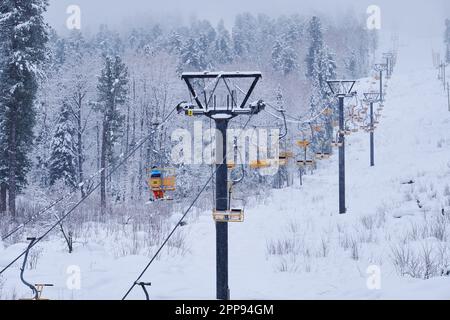 Skigebiet Teletsky Altai in den Winterbergen bei Iogach. Aufzug auf dem Berg und Waldhintergrund bei Schneefall. Stockfoto