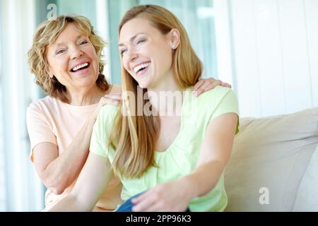 Alle lächeln und lachen. Eine Mutter und Tochter, die glücklich zusammen lachen. Stockfoto