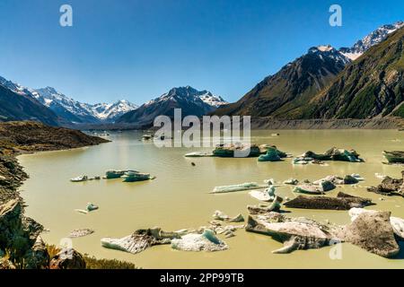 Eisberge am Tasman-See treiben auf der alpinen Seenoberfläche mit den höchsten schneebedeckten Gipfeln der südlichen alpen im Hintergrund Stockfoto