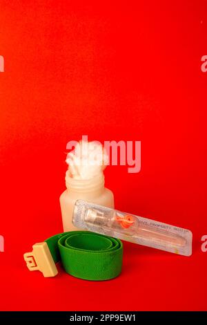 Baumwollfaserstruktur in der weißen Flasche mit iv-Kanüle. Isoliert auf rotem Hintergrund Stockfoto