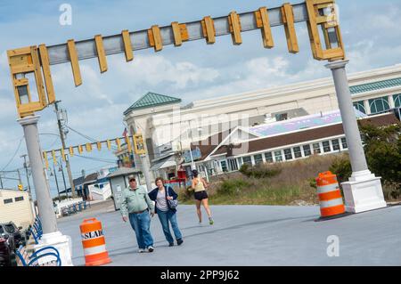 Cape May, Usa. 22. April 2023. Ein Paar fährt am Samstag, den 22. April 2023, entlang der Promenade in Cape May, New Jersey, durch die im Bau befindlichen Cape May Promenade. Die Torbögen werden als Rückkehr eines malerischen Details des alten Cape May gesehen, dessen ursprüngliche Bögen 1944 durch einen Hurrikan zerstört wurden. ( Kredit: William Thomas Cain/Alamy Live News Stockfoto