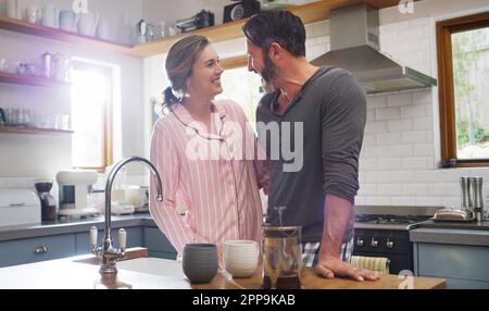 Guten Morgen, mein Sonnenschein. Ein liebevolles Paar, das zu Hause in der Küche steht. Stockfoto