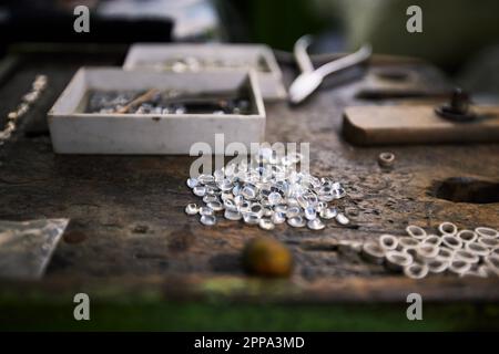 Ein Haufen verarbeitete Mondsteine, bereit für die Schmuckherstellung auf dem Arbeitstisch. Stillleben mit Edelsteinen in einer Werkstatt in Sri Lanka. Stockfoto