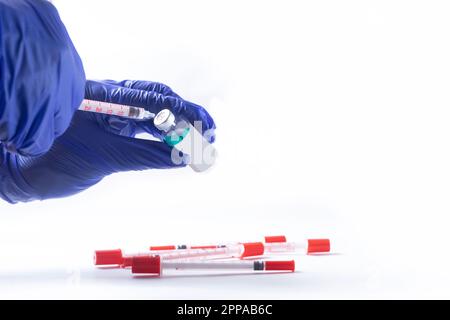 Der Arzt wählt den Impfstoff in eine Spritze auf weißem Hintergrund. Stockfoto