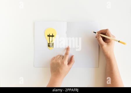 Menschliche Hand Schreibkarte mit Glühbirne Stockfoto