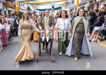 Huelva, Spanien - 18. März 2023: Ein Baby fährt in einer rustikalen, mit historischen Kostümen verkleideten Kinderwagen in der Parade der mittelalterlichen Discove Stockfoto