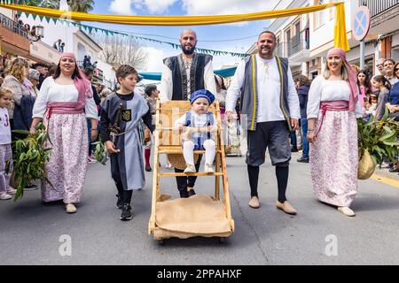 Huelva, Spanien - 18. März 2023: Ein Baby fährt in einer rustikalen, mit historischen Kostümen verkleideten Kinderwagen in der Parade der mittelalterlichen Discove Stockfoto