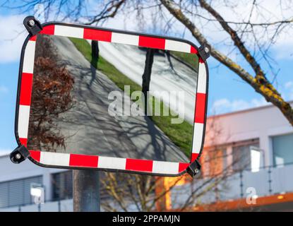 Leere Straße, die sich in einem Verkehrsspiegel widerspiegelt Stockfoto