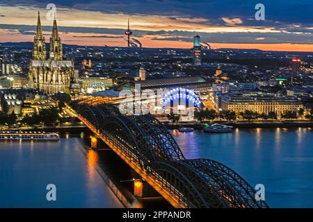 KÖLN, DEUTSCHLAND - 12. MAI: Nächtliches Stadtbild von Köln am 12. Mai 2019. Blick vom Dreiecksturm auf die Kathedrale und die Hohenzolernbrücke Stockfoto