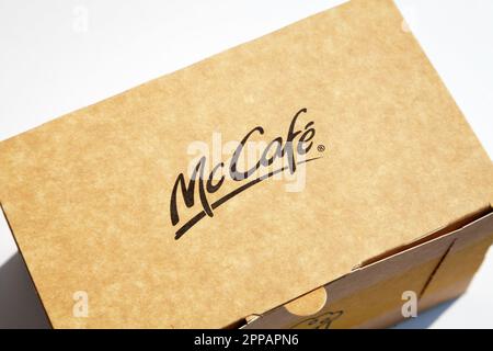 Ho-Chi-Minh-Stadt, Vietnam - 20. April 2023: McCafe-Logo auf einer geschlossenen braunen Pappschachtel mit einem Dessert im Inneren. Beliebtes Produkt einer Café-Kette mit CO Stockfoto