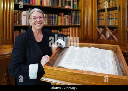 Sydney, Australien. 21. April 2023. Maggie Patton, Leiterin der Sammlungsakquise und Kuration in der New South Wales State Library (NSW), steht neben dem ersten Folio in der NSW State Library in Sydney, Australien, am 21. April 2023. Jedes Jahr am 23. April, wenn der Weltbuchtag mit dem Todestag von William Shakespeare zusammenfällt, wird ein verstecktes Juwel im Herzen von Australiens Sydney seine Tür öffnen und Bücherwürmer willkommen heißen, wie versprochen. Am World Book Day besuchen Sie Shakespeare in seiner „versteckten Ecke“ in Australiens Sydney. Credit: Wang Qi/Xinhua/Alamy Live News Stockfoto