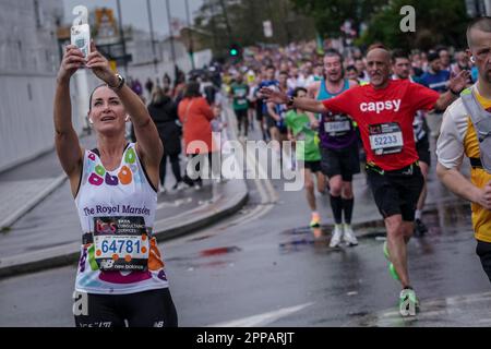 London, Großbritannien. 23. April 2023. Kirsty Gallacher, ehemaliger Sky Sports-Moderator, hält für ein paar Selfies an, während der London Marathon die Deptford's Evelyn Street im Südosten Londons passiert, die 8 km lange Strecke der 26,2 km langen Strecke, auf der Läufer von den Einheimischen begrüßt und bejubelt werden. Kredit: Guy Corbishley/Alamy Live News Stockfoto