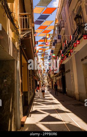 Badajoz, Spanien - 24. Juni 2022: Gasse mit mehrfarbigen Markisen im Zentrum von Badajoz Stockfoto