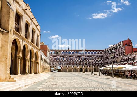 Badajoz, Spanien - 24. Juni 2022: Fassaden der farbenfrohen Gebäude und Häuser auf dem Alta-Platz in Badajoz unter einem Bogen (Spanien) Stockfoto