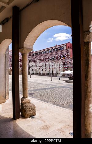 Badajoz, Spanien - 24. Juni 2022: Fassaden der farbenfrohen Gebäude und Häuser auf dem Alta-Platz in Badajoz unter einem Bogen (Spanien) Stockfoto