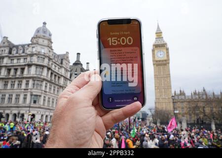 Ein Test eines neuen öffentlichen Alarmsystems, das einen lauten Alarm auf einem Mobiltelefon in Westminster, Central London, aussendet. Foto: Sonntag, 23. April 2023. Stockfoto